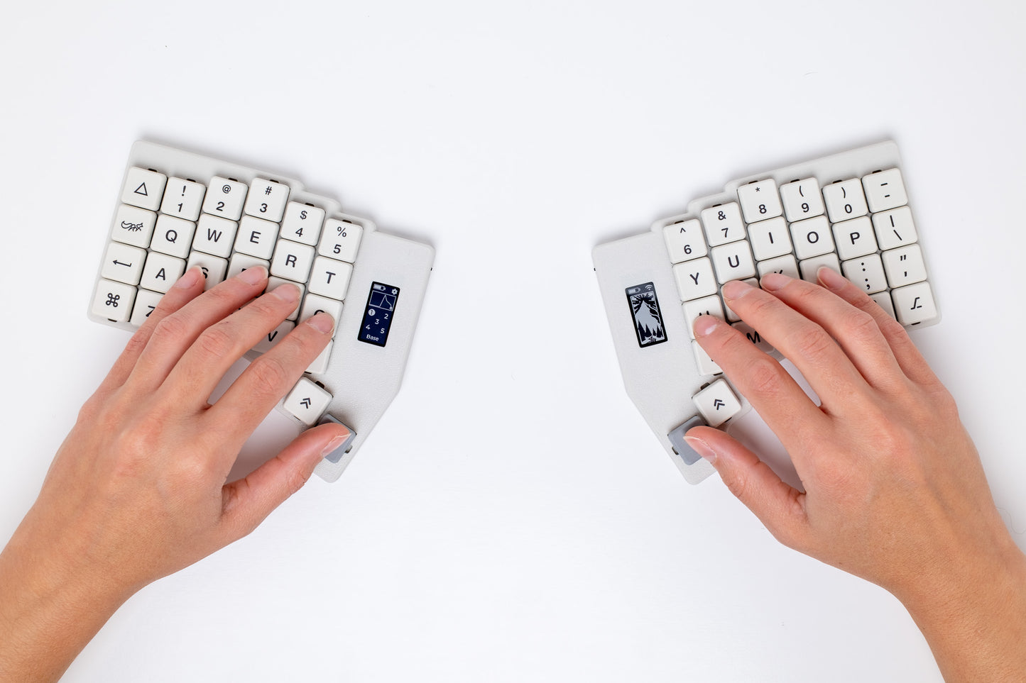 Two hands typing on the Mantaray Pro Wireless with a white background